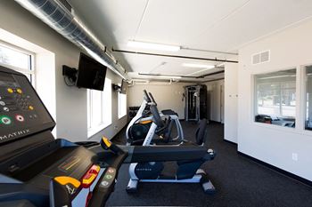 A gym with treadmills and elliptical machines.